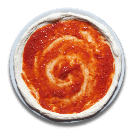 Zdjęcie przedstawiające ciasto z rozłożonym sosem pomidorowym